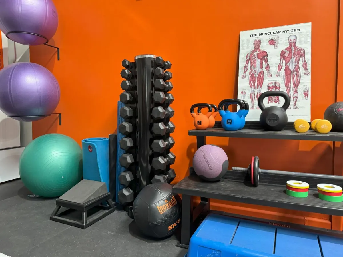 Gym equipment against the brand orange wall